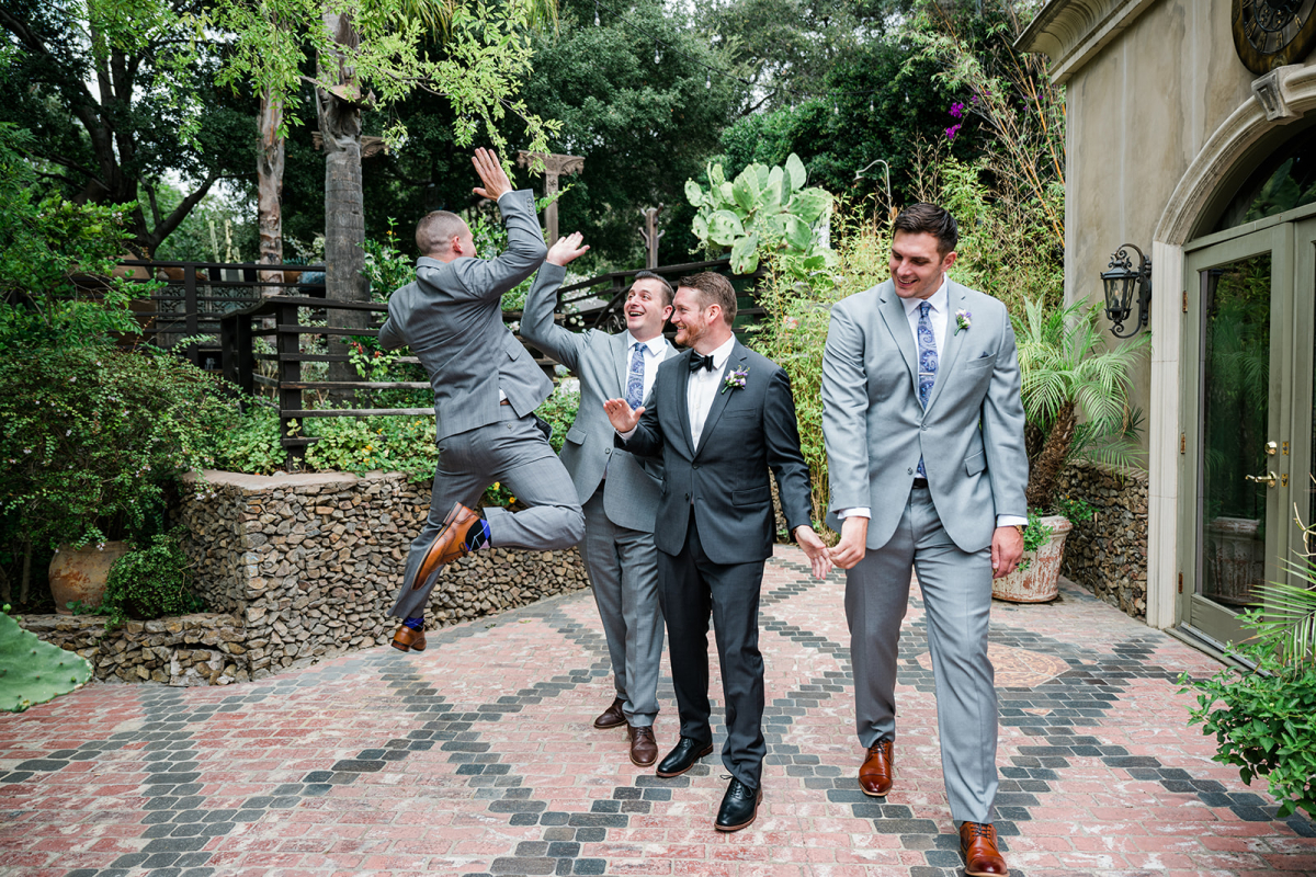 Groomsmen mid-air in a fun, energetic jump for joy pose.